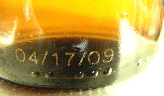 Expiry date code on amber glass bottle, mark made by Matthews Marking Systems laser