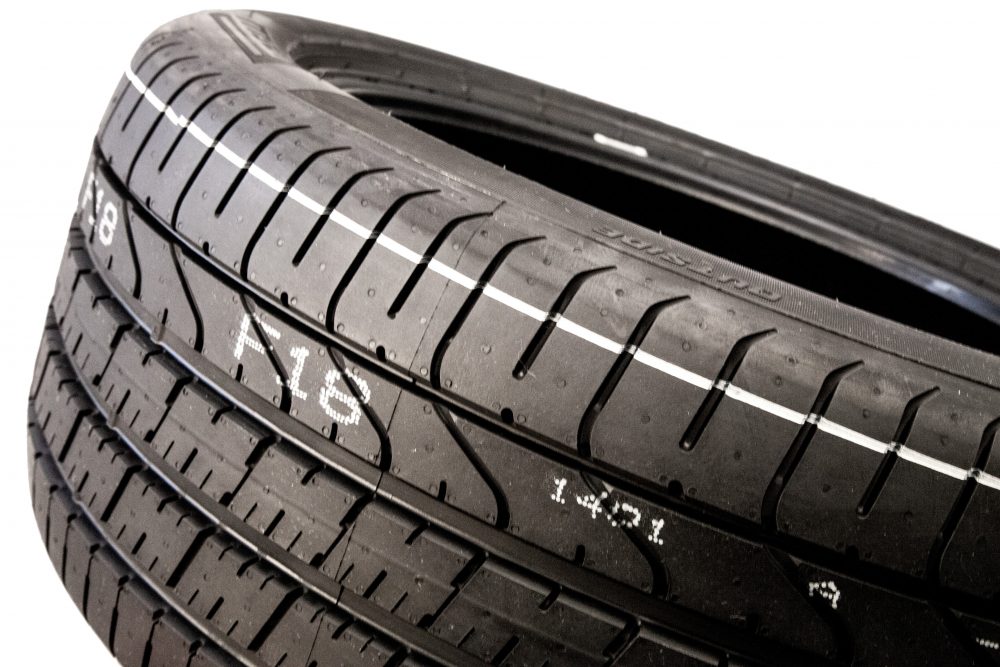 Rubber tire with striping and human readable text mark made by valve jet