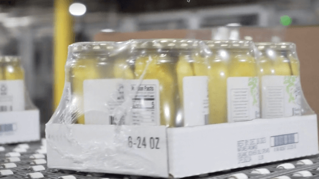 Case of pickles traveling down conveyor